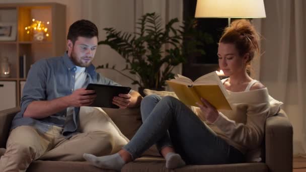 Couple avec tablette et livre à la maison — Video