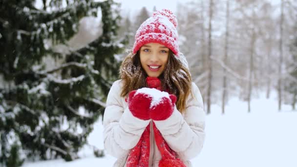 Ευτυχισμένη γυναίκα φυσώντας να χιόνι στο δάσος του χειμώνα — Αρχείο Βίντεο