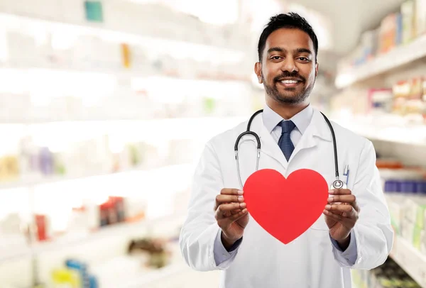 Mosolyogva indiai férfi orvos és piros szív alakú — Stock Fotó