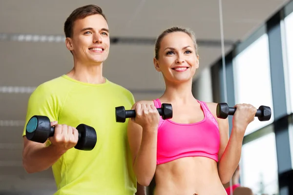 Pareja con mancuernas haciendo ejercicio en el gimnasio —  Fotos de Stock