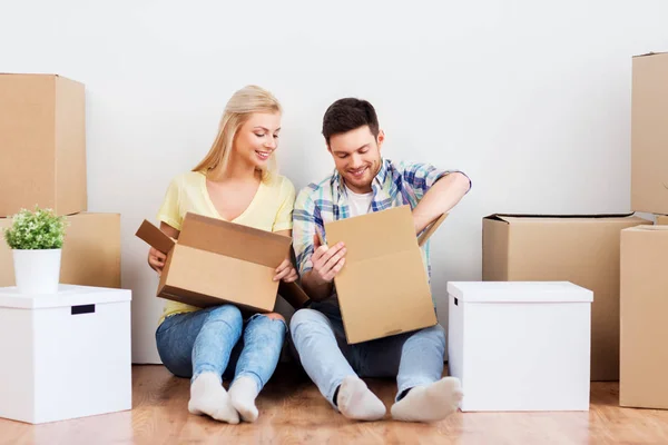 Feliz pareja desembalaje cajas en nuevo hogar — Foto de Stock