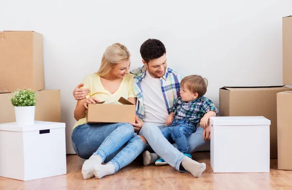 Happy family with boxes moving to new home — Stock Photo, Image