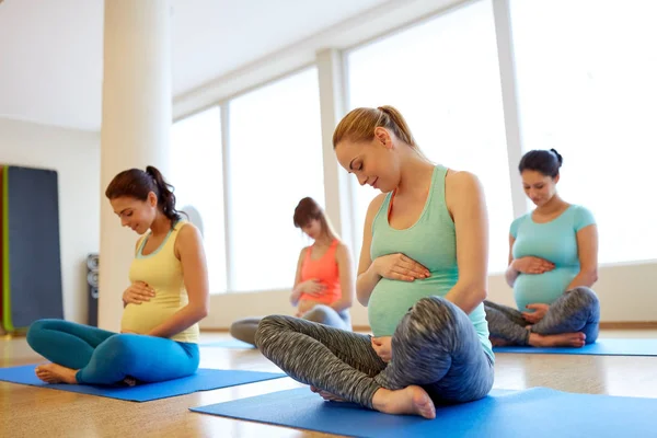 Счастливые беременные женщины, занимающиеся в спортзале йогой — стоковое фото