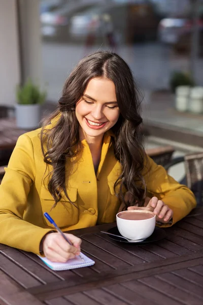 Mulher feliz com notebook beber cacau no café — Fotografia de Stock