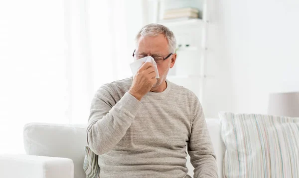 Άρρωστος ανώτερος άνθρωπος με χαρτί σκουπίστε φυσάει τη μύτη του — Φωτογραφία Αρχείου