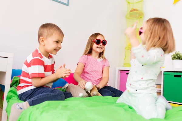 Fröhliche kleine Kinder mit Sonnenbrille spielen zu Hause — Stockfoto
