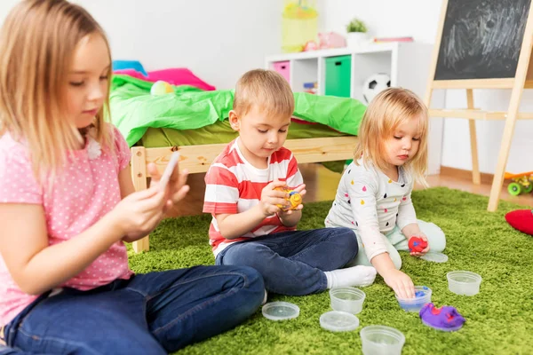 Children with modelling clay or slimes at home — Stock Photo, Image