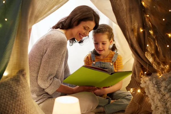 Felice famiglia lettura libro in tenda per bambini a casa — Foto Stock