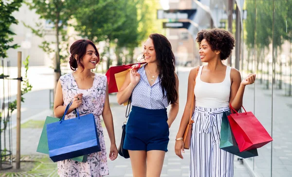 Щасливі жінки з сумками, що ходять по місту — стокове фото