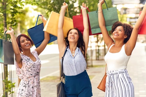 Donne felici con borse della spesa sulla strada della città — Foto Stock