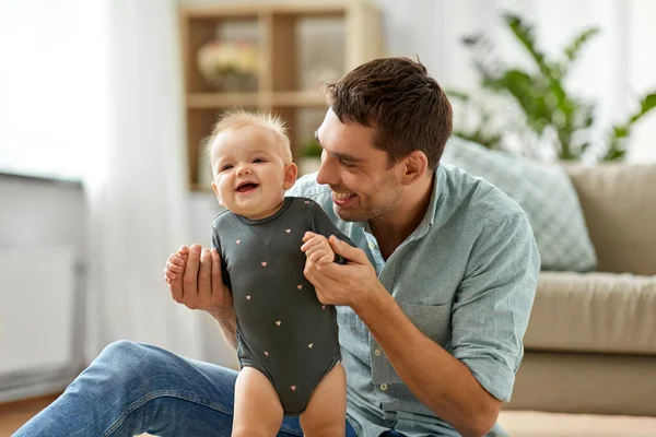 Feliz padre sosteniendo pequeña hija bebé en casa —  Fotos de Stock