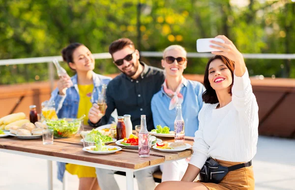 Glada vänner tar selfie på taket fest — Stockfoto