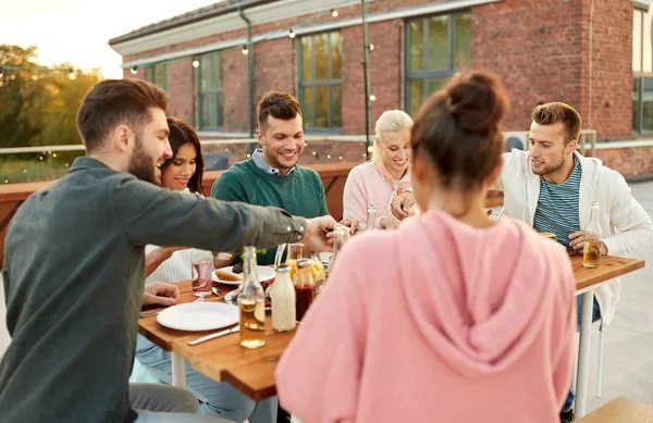 Amici che cenano o fanno festa sul tetto in estate — Foto Stock