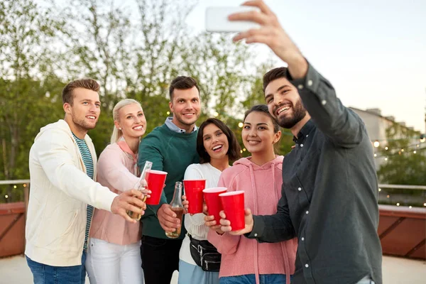 Φίλοι με ποτά λήψη selfie σε πάρτι στον τελευταίο όροφο — Φωτογραφία Αρχείου