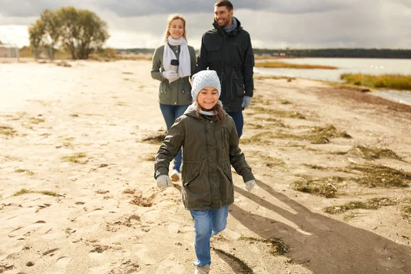 Família feliz andando ao longo da praia de outono — Fotografia de Stock