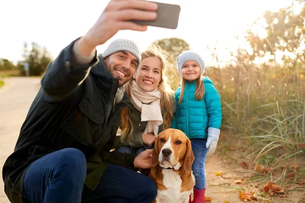 Lycklig familj med hund tar selfie i höst — Stockfoto