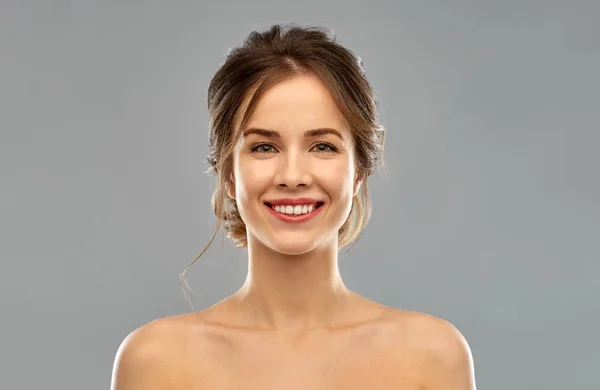 Smiling young woman over grey background — Stock Photo, Image