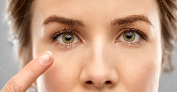 Close up of woman pointin finger to eye — Stock Photo, Image