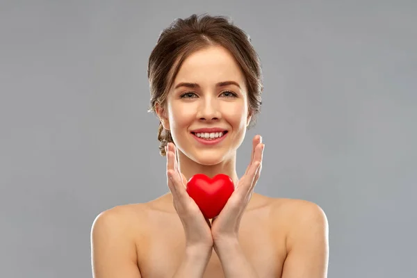 Bela mulher sorridente segurando coração vermelho — Fotografia de Stock