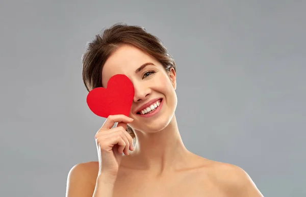 Hermosa mujer sonriente sosteniendo el corazón rojo — Foto de Stock