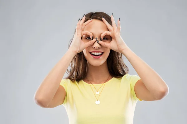 Mujer joven mirando a través de gafas de dedo —  Fotos de Stock