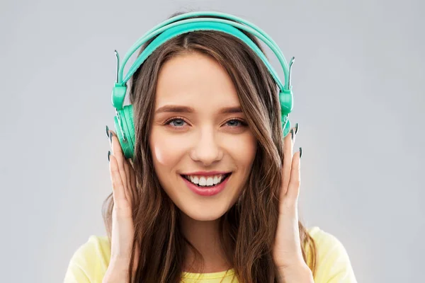 Šťastná mladá žena nebo dospívající dívka se sluchátky — Stock fotografie