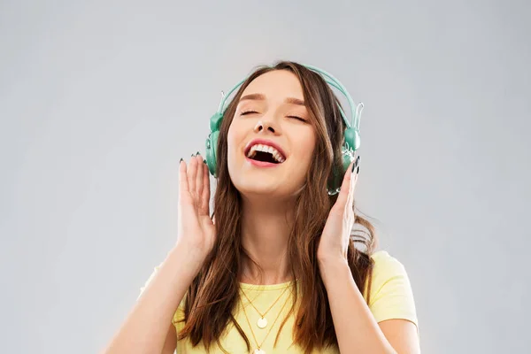 Щаслива молода жінка або дівчина-підліток з навушниками — стокове фото