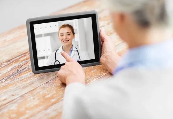 Paciente de edad avanzada que tiene videollamada con médico —  Fotos de Stock