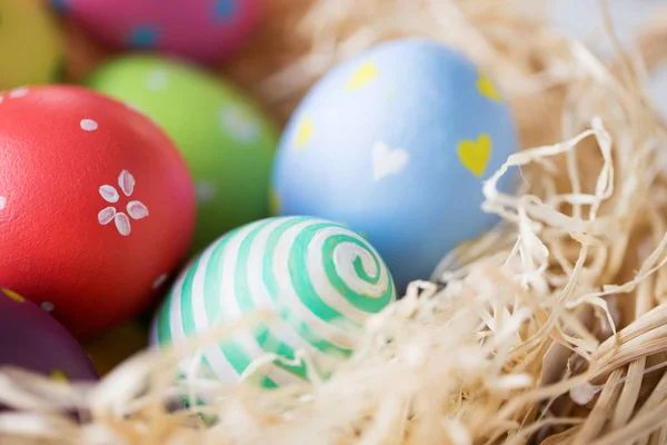 Primer plano de huevos de Pascua de colores en paja —  Fotos de Stock