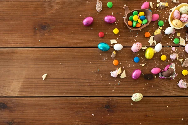 Çikolata yumurta ve şeker damla üzerinde ahşap masa — Stok fotoğraf