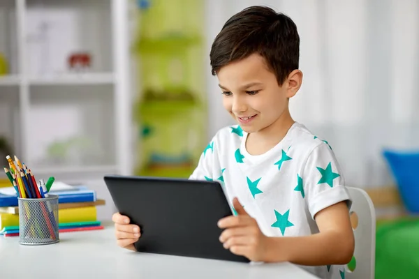 Menino estudante com tablet pc e notebook em casa — Fotografia de Stock