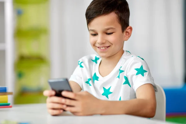 Menino feliz com smartphone em casa — Fotografia de Stock