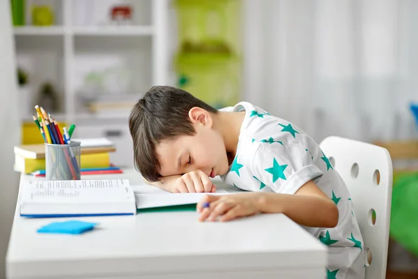 Yorgun öğrenci çocuk evde masaya yatıyor — Stok fotoğraf
