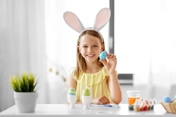 Happy girl coloring easter eggs at home — Stock Photo, Image