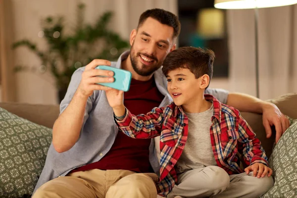 Pai e filho tomando selfie em casa — Fotografia de Stock