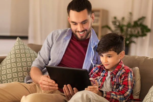 Father and son listening to music on tablet pc — Stock Photo, Image