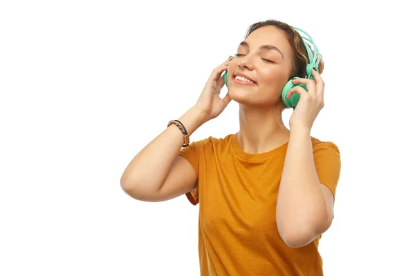 Szczęśliwa młoda kobieta lub nastolatka ze słuchawkami — Zdjęcie stockowe
