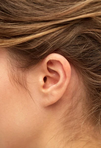 Close-up van jonge vrouw wijzend vinger naar haar oor — Stockfoto