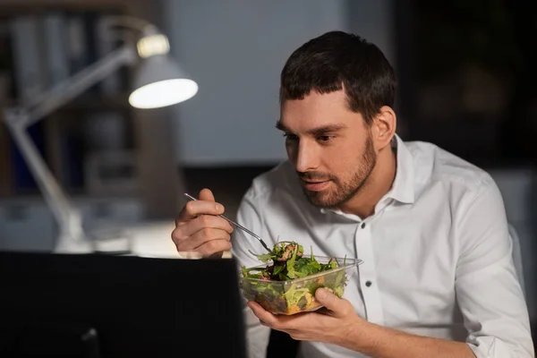 Podnikatel s počítačem jíst v noci kancelář — Stock fotografie