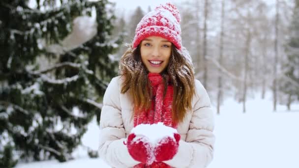 Glad ung kvinna kastar snö i vinter skog — Stockvideo