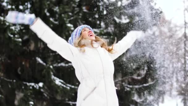 Glad ung kvinna kastar snö i vinter skog — Stockvideo