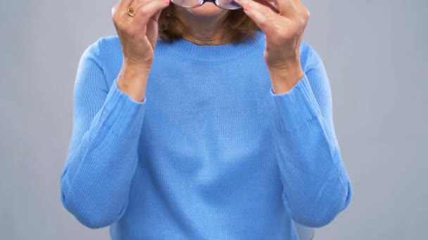 Portrait of happy senior woman putting glasses on — Stock Video