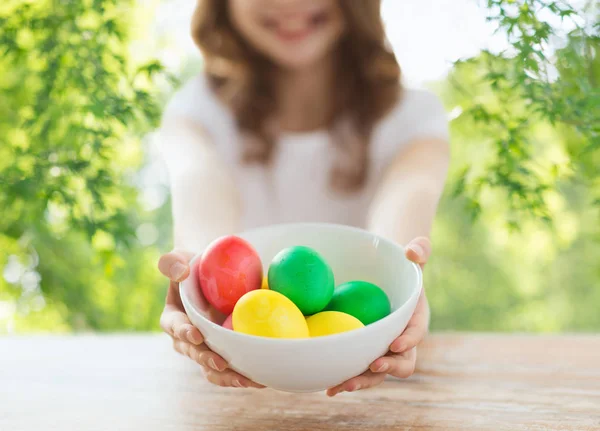 Close up of girl with bowl of colored easter eggs — Stock Photo, Image