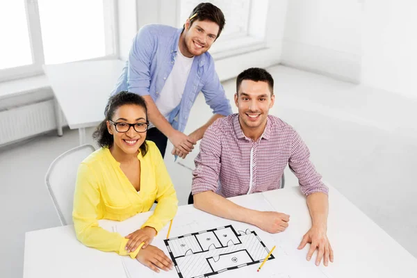 Creative team with blueprint working at office — Stock Photo, Image