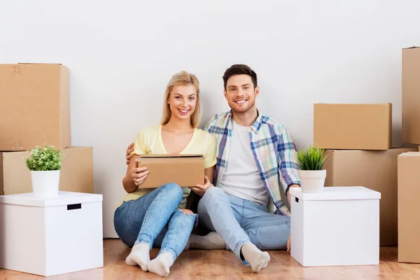 Feliz pareja con cajas mudándose a un nuevo hogar — Foto de Stock