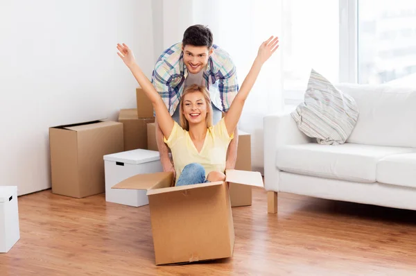 Feliz pareja divirtiéndose con cajas en nuevo hogar —  Fotos de Stock