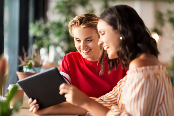 Amigos do sexo feminino com tablet pc e café no café — Fotografia de Stock