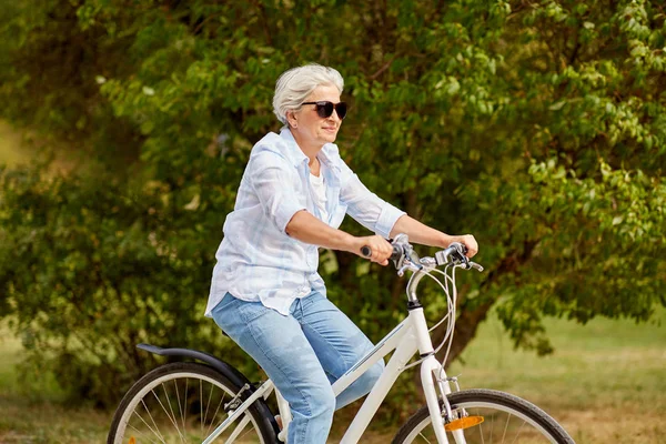 夏の公園で幸せな先輩女乗って自転車 — ストック写真