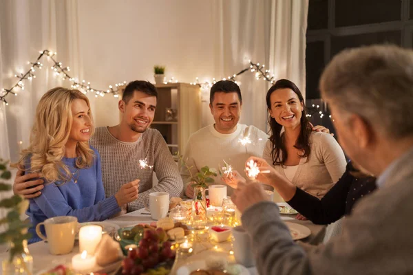 Familj med tomtebloss med middagsbjudning hemma — Stockfoto