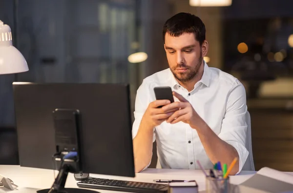 Homme d'affaires avec smartphone et ordinateur au bureau — Photo